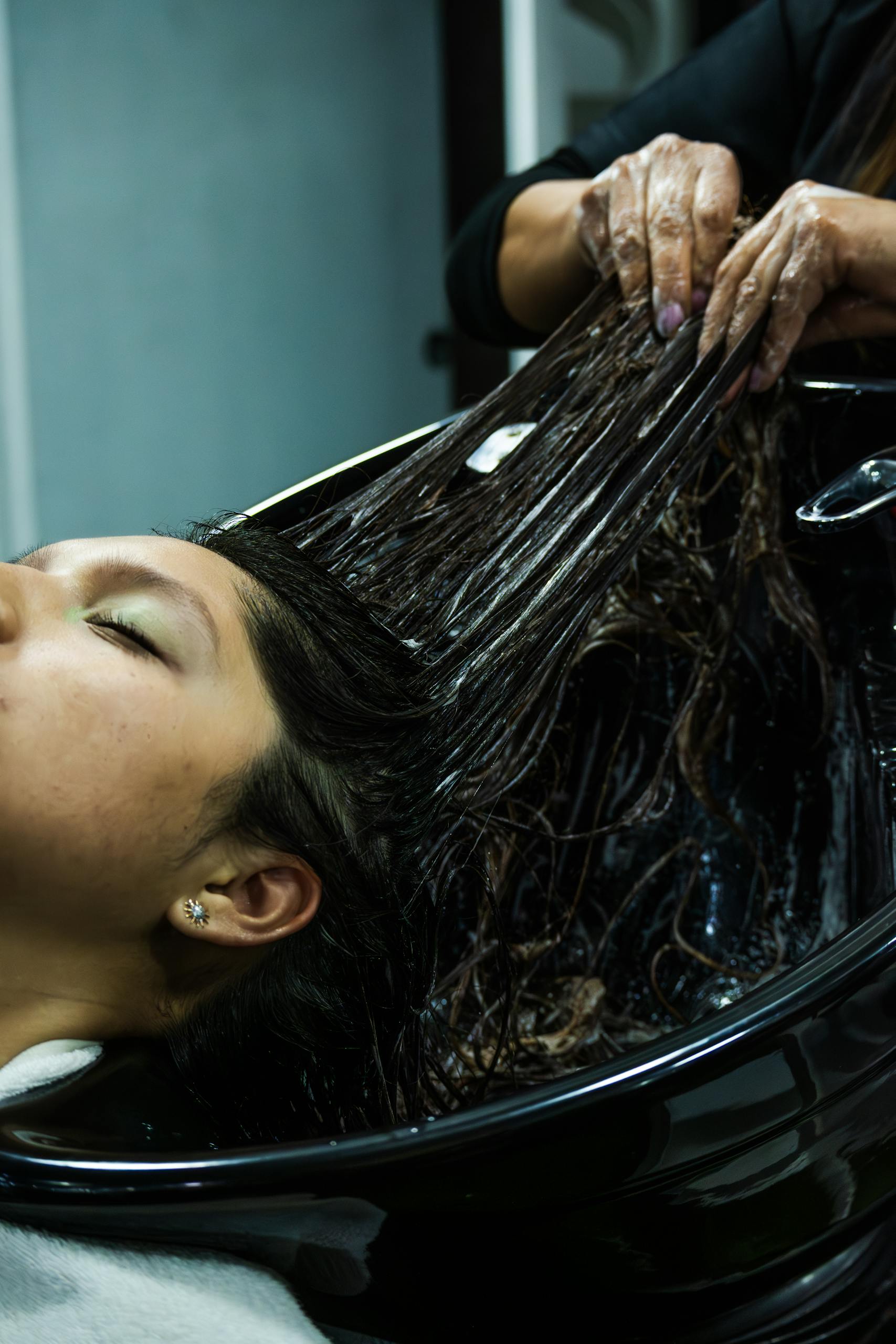 Woman receiving a luxurious hair treatment at a spa in Cuenca, Ecuador, promoting relaxation.