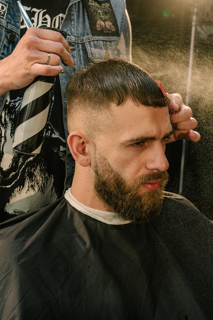 A bearded man getting a fresh haircut at a stylish barber shop.
