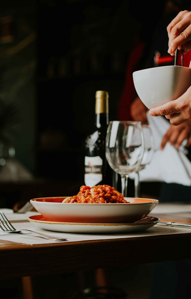A sophisticated Italian dining scene featuring spaghetti and wine, perfect for a cozy evening out.