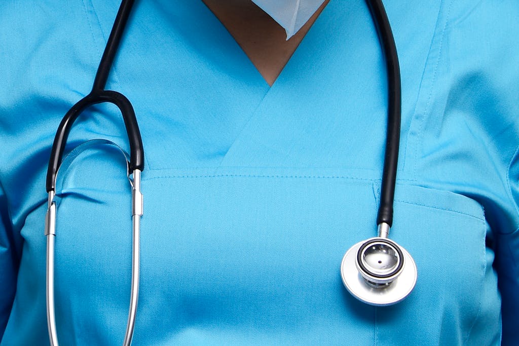 Detailed image of a medical professional wearing scrubs and a stethoscope, symbolizing healthcare.